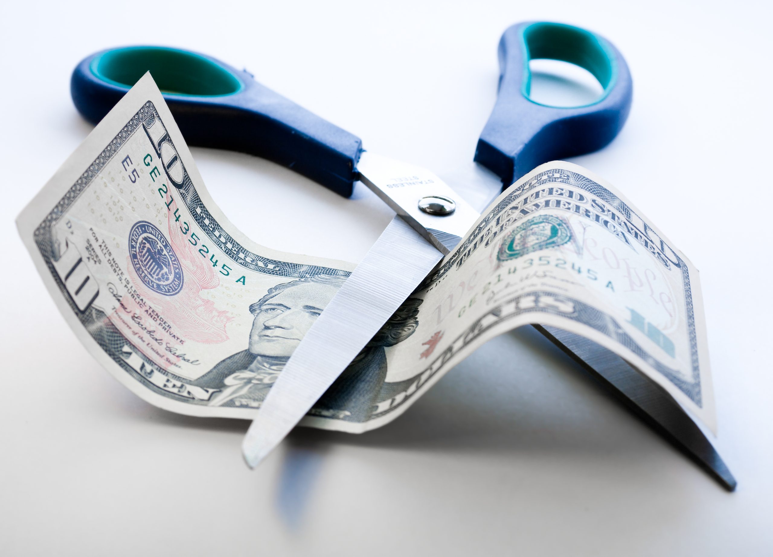 Scissors,Cutting,Through,Dollar,Note,On,White,Background